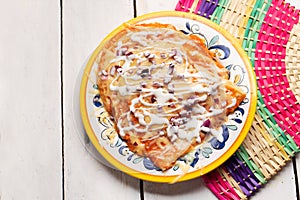 Mexican red enchiladas with melted cheese on white background