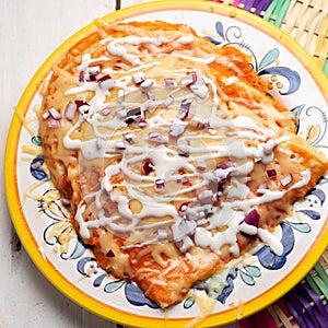 Mexican red enchiladas with melted cheese on white background