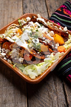 Mexican red enchiladas with potato and pork chorizo also called Potosinas on wooden background photo