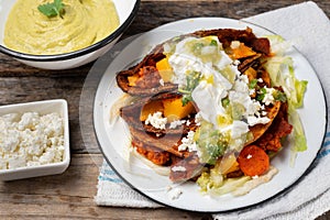 Mexican red enchiladas with potato and pork chorizo also called Potosinas on wooden background