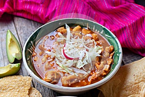 Mexican red pozole soup on wooden background photo