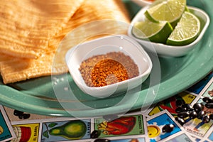Traditional Mexican snack durito chicharrÃ³n with chili lemon and salt garnished with Mexican lottery game