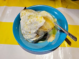 A traditional Michoacan corunda smothered in rich cream and green sauce, food