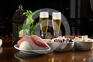 Traditional Middle Eastern food. Lebanese food. Arabian raw kibbeh, olives, cheese, beer glass