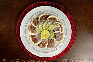 Traditional Middle Eastern food. Lebanese Sfiha meat. Arabian sfeeha plate. Esfiha with lemons on a wood base. Top view