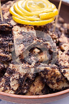 Traditional Moldovan and Romanian festive dish of sweet cakes and poppy filling, decorated with wedges of lemon.