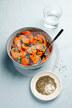 Traditional Moroccan cooked carrot salad North African vegan dish with chopped parsley and olives on gray plate top view