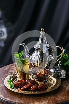Traditional moroccan mint tea with copper teapot, dates and sugar