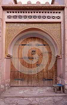 Traditional Moroccan style design of an ancient wooden entry door. In the old Medina in Ourzazate, Morocco. Typical, old