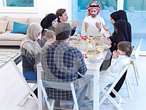 Traditional muslim family praying before iftar dinner