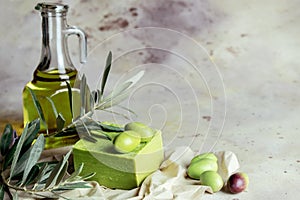 Traditional natural organic olive soap. Handmade soap bar with green olives, leaves and glass jar of olive oil on rustic