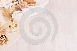 Traditional natural rustic spa white cosmetics products and beige bath accessories on light wood background, top view, border. photo