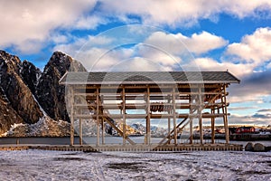 Traditional Norwegian wooden constructions for cod fish drying and red rorbu, fishing houses. Winter landscape on the Lofoten