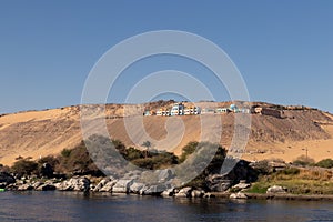 Traditional nubian village on the top of the sand hill in the bank of the Nile river with vegetation and blue clear sky