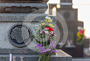 Traditional offering of flowers, incense and candles on a tomb in a Japanese graveyard. Kanazawa city, Ishikawa Prefecture photo