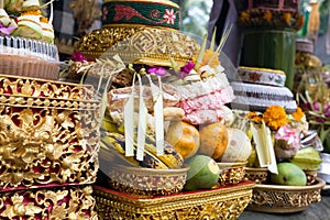 Traditional offerings to gods in Indonesia with flowers, fruits and aromatic sticks in temple, buddhist
