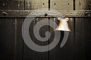 Traditional old door bell for ring on old wooden door, vintage background textue