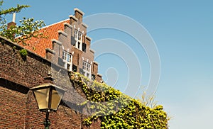 A traditional old Dutch house with a staircase roof and orange tiles