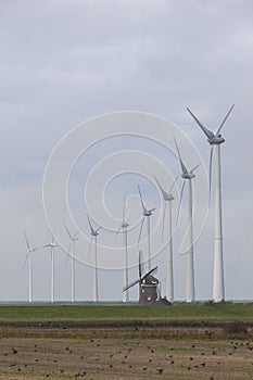 Traditional old dutch windmill goliath and wind turbines near eemshaven in the northern province groningen of the netherlands