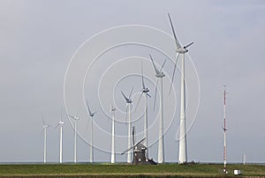 Traditional old dutch windmill goliath and wind turbines near eemshaven in the northern province groningen of the netherlands