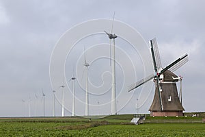 Traditional old dutch windmill goliath and wind turbines near eemshaven in the northern province groningen of the netherlands