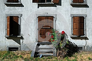Traditional old house facade with red roses in Les Houches, Chamonix