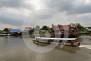 A traditional old house by the river with boats passing by. on creativity