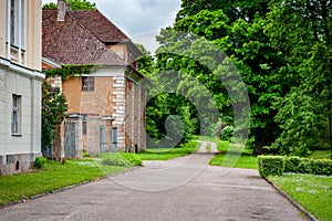 A traditional old manor house in the countryside with a road leading into the distance.