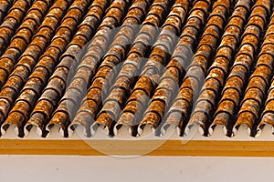 Traditional old Spanish ceramic roof tiles on a building, characteristic elements of Mediterranean architecture