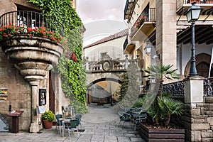 Traditional old Spanish street with beautiful balconies and arches in Barcelona town, Spain