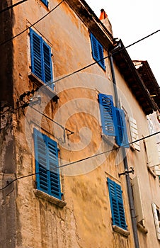 Details of a traditional old house with wooden blue shutters