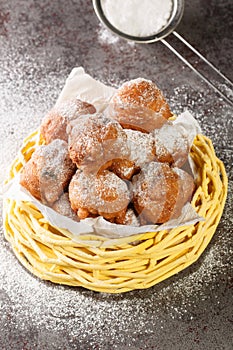 Traditional oliebollen, oil dumpling or fritter, for Dutch New Year Eve closeup in the basket. Vertical