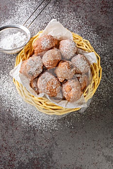 Traditional oliebollen, oil dumpling or fritter, for Dutch New Year Eve closeup in the basket. Vertical top view