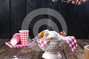 Traditional oliebollen, oil dumpling or fritter, with wooden spoon, for Dutch New Year`s Eve .Copy space