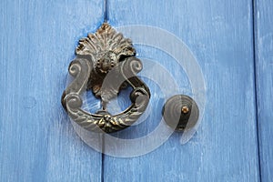 Traditional ornate door handle or knocker against a blue painted wooden door, Cartagena, Colombia