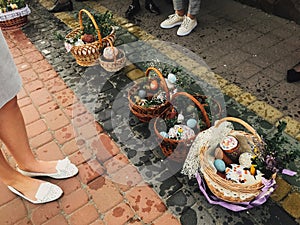 Traditional orthodox Easter food for blessing. Easter baskets with stylish painted eggs, easter cake, ham, butter, candle with photo