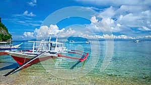 Traditional outrigger boats on a tropical island in the Philippines.