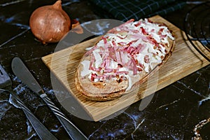 Traditional oval shaped food `Tarte Flambee` or `Flammkuchen` from German-French Alsace border region.