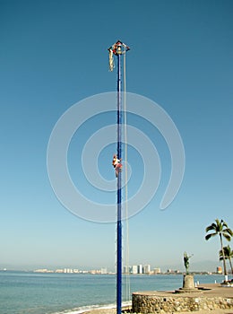Traditional Palo Volador flying man climbing 30 meter wooden pole. Puerto Vallarta photo