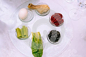 Traditional Passover seder plate with symbolic meal for Passover or Pesach Seder on white background, top view.