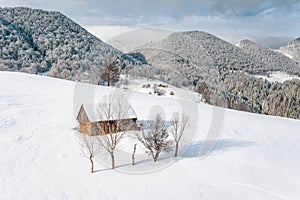 Traditional peasant house covered with snow in the Pestera Village near Moeciu and Bran Romania