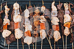 Traditional Peruvian food `Anticuchos`, grilled skewered beef heart meat, cooked on barbecue grill