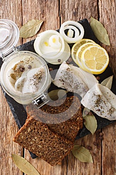 Traditional pickled herring in a jar with ingredients close-up. Vertical top view