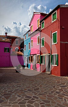 Traditional pink, bordeau and blue houses in Burano, Venice, Italy