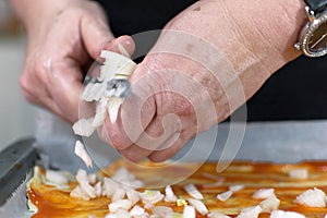 Traditional pizza cooking by italian chef at home. Adding some onion. adding ingredients on top