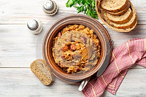 Traditional Polish dish Bigos in ceramic bowl on rustic wooden table