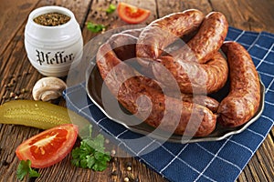 Traditional Polish sausage on an old plate, on old wooden boards