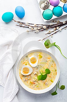 Traditional Polish sour soup Zurek in ceramic bowl for Easter