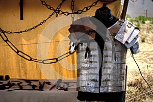Traditional polished roman armour placed on a manikin in a yellow tent