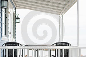 Traditional porch or portico deck interior- exterior space in front of vacation white blue beach house under the roof